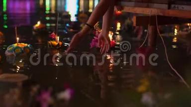 人们个人把一支燃烧着的蜡烛放在满是漂浮充满漂浮的克拉通的水中。 庆祝泰国传统节日